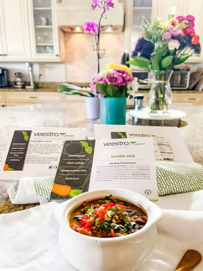 Photo of veestro vegan chili in a kitchen with the boxes behind it.