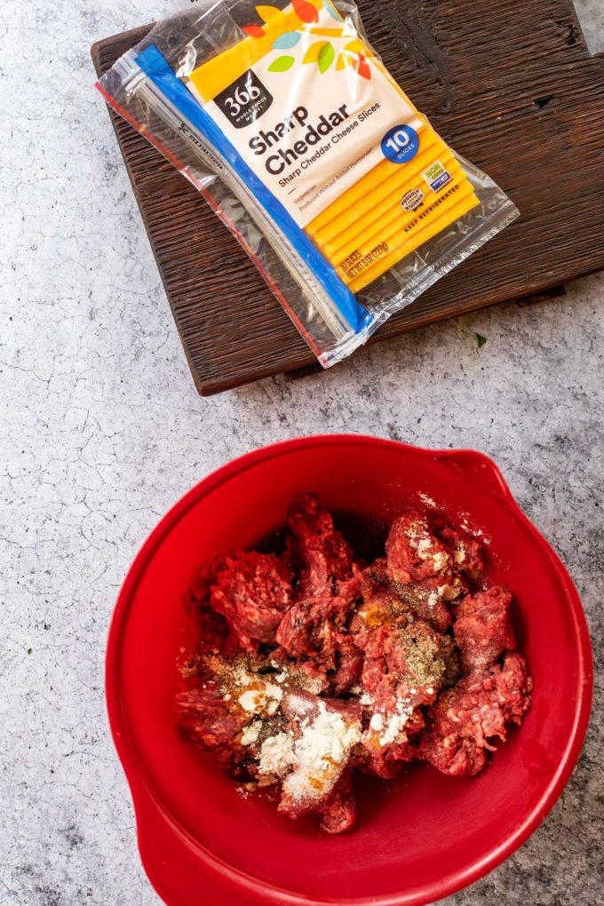 A red bowl with seasoned ground beef.