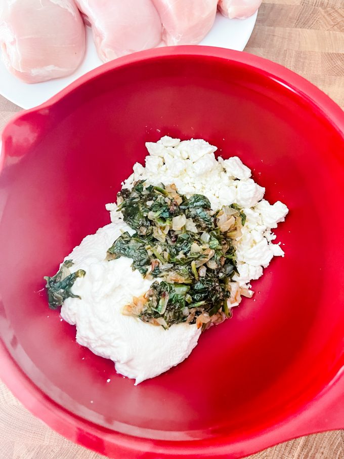 Photo of a ricotta, feta, spinach and onion mixture in a bowl.