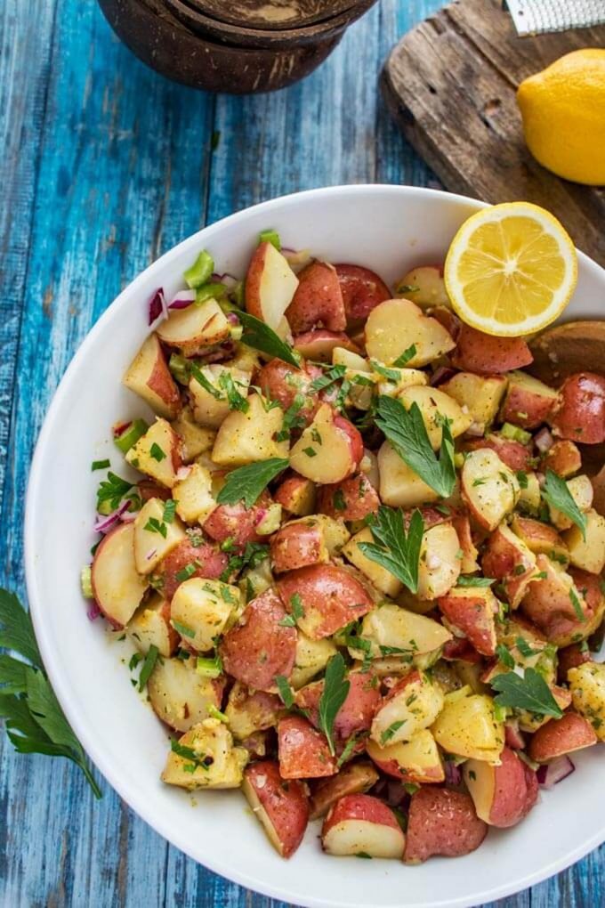 Overhead close up photo of Instant Pot Red Potato Salad garnished with parsley with a lemon sitting in the bowl.
