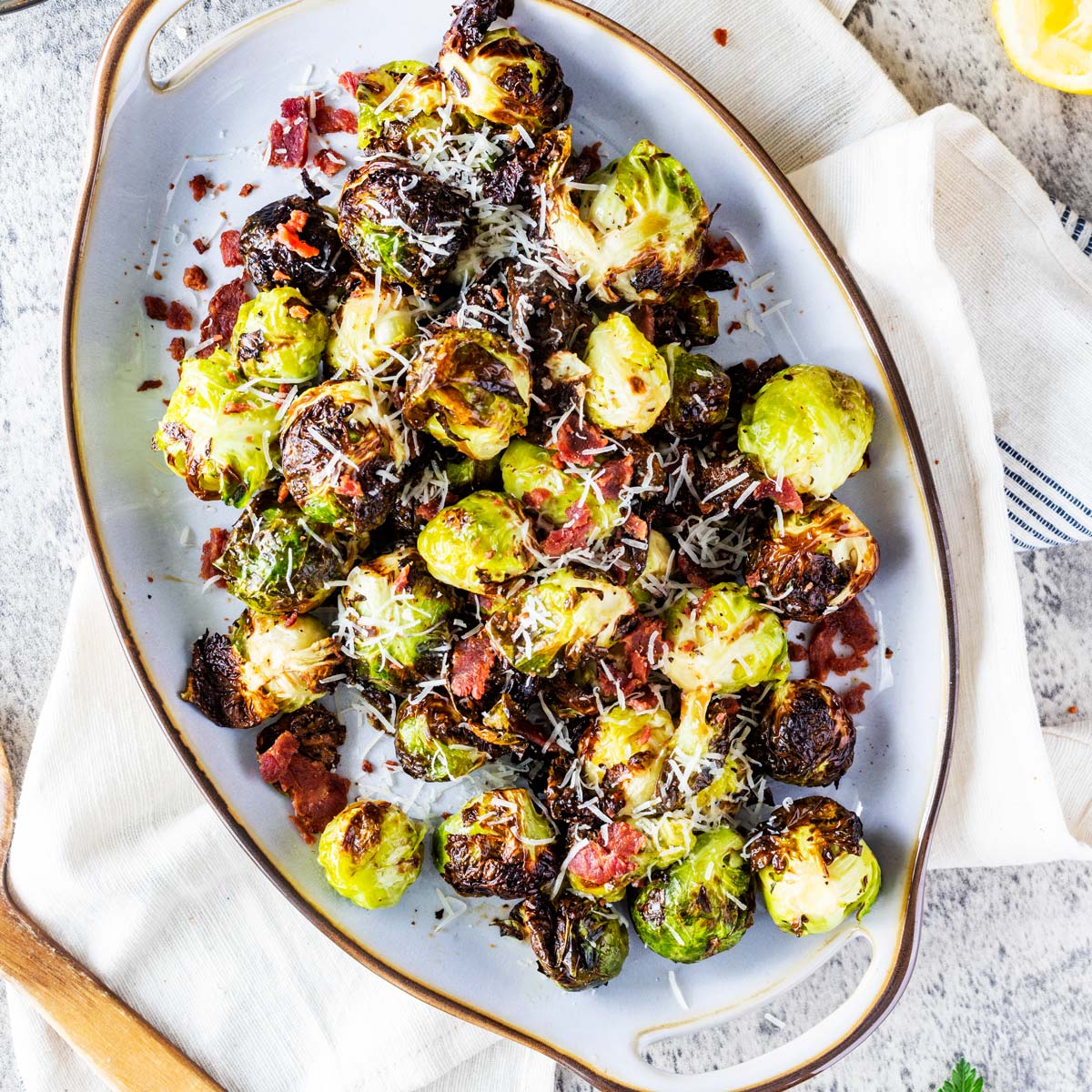 Square overhead photo of a serving platter with Ninja Foodi Grill Brussels sprouts on it.