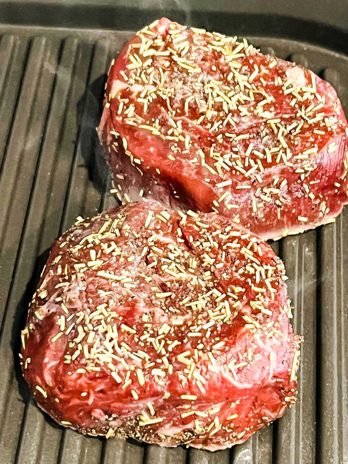 Close up photo of grilled filet mignon cooking on a ninja foodi grill.