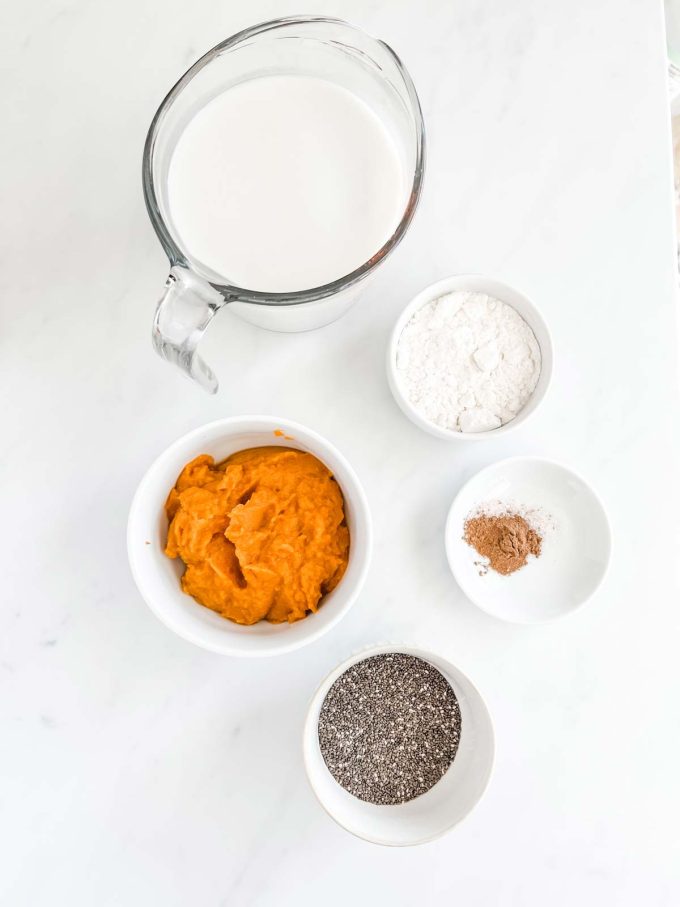 Photo of almond milk, chia seeds, sweetener, pumpkin puree, pumpkin pie spice, and sea salt in prep containers.