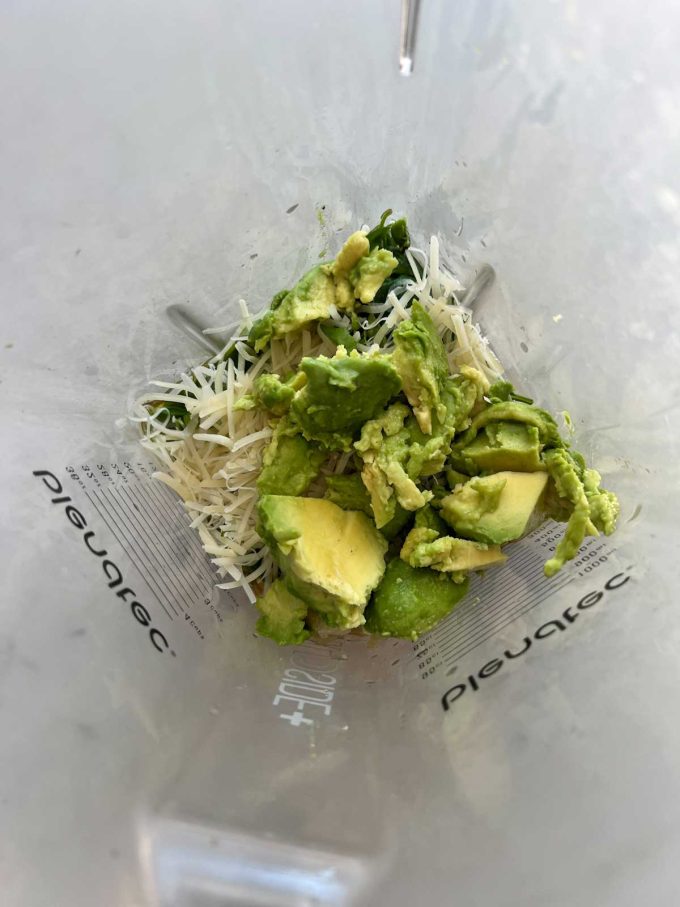 Photo of the ingredients for avocado pesto in a blender.