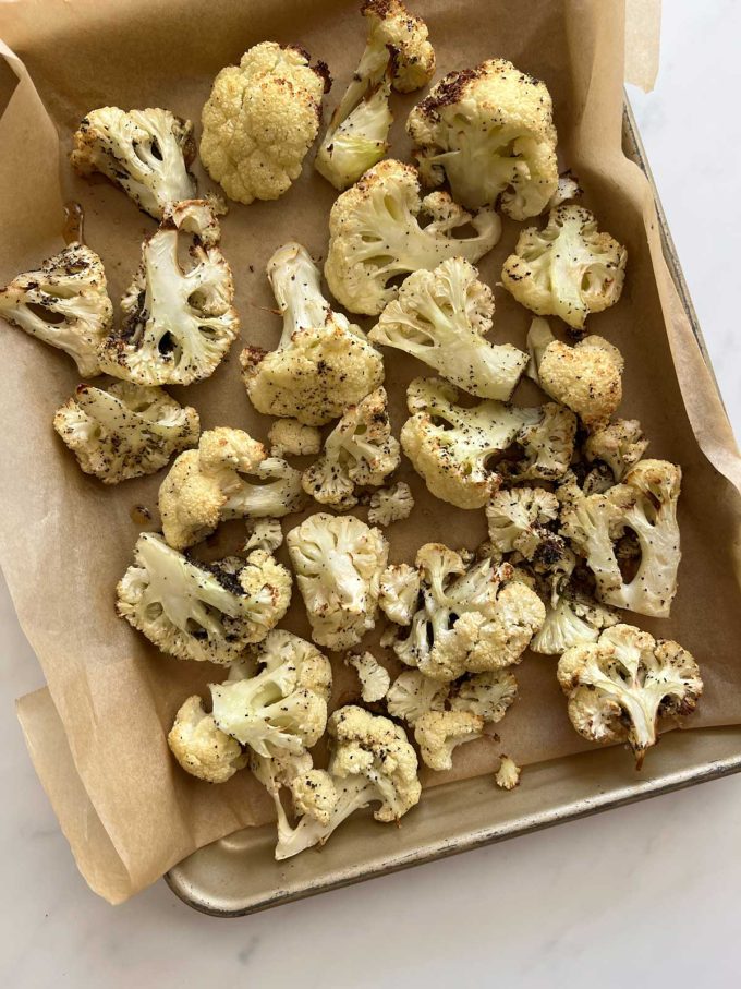 Photo of cauliflower that has been seasoned and roasted on a sheet pan.