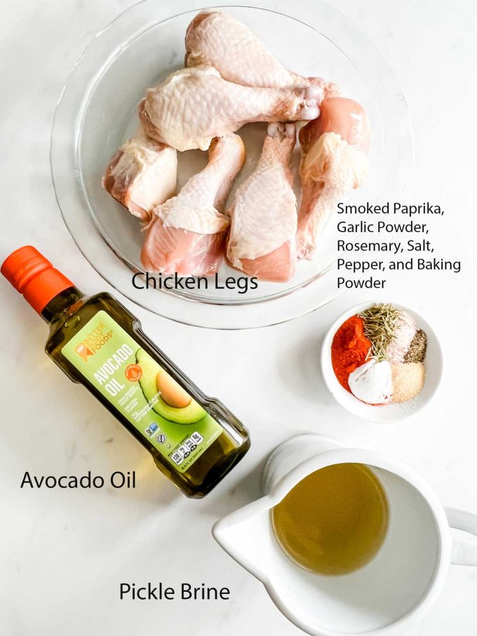 Overhead photo of chicken legs, seasonings, pickle brine, and avocado oil.