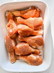 Overhead photo of seasoning chicken legs.