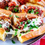 Square photo of meatball subs with a cheese pull.