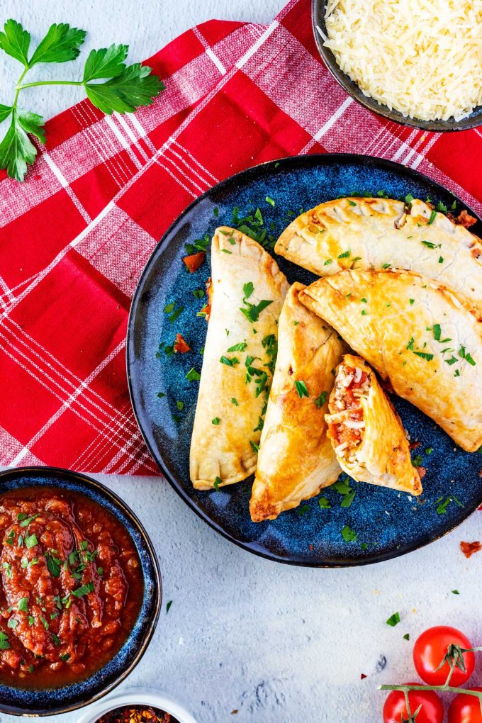Overhead photo of a plate of air fryer pizza pockets garnished with parsley.