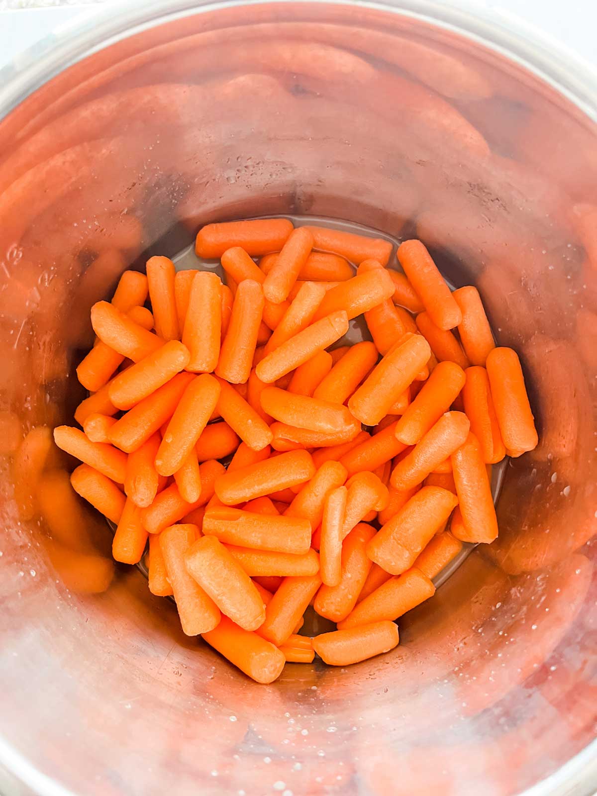Photo of baby carrots over broth in an Instant Pot.