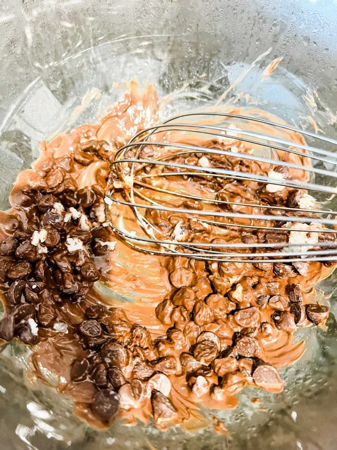 Photo of chocolate chips and coconut oil melting in a glass bowl.