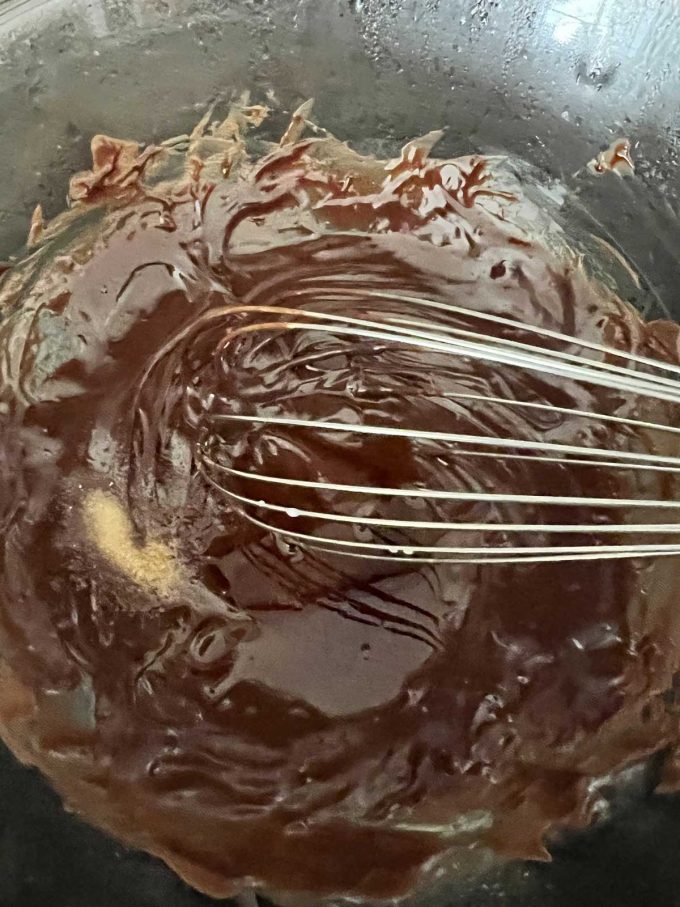 Photo of the filling for chocolate tarts that has just had vanilla extract poured into it.