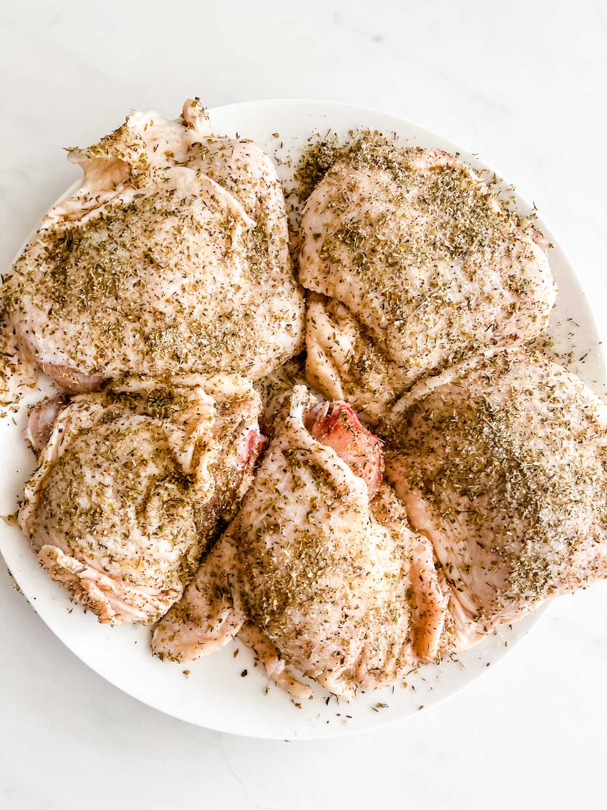 Photo of a plate of seasoned chicken thighs.