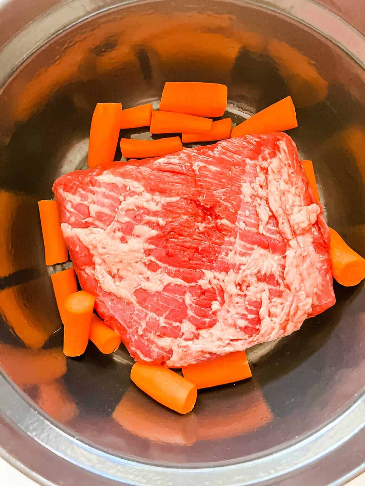 Photo of corned beef and carrots in a Dutch Oven.