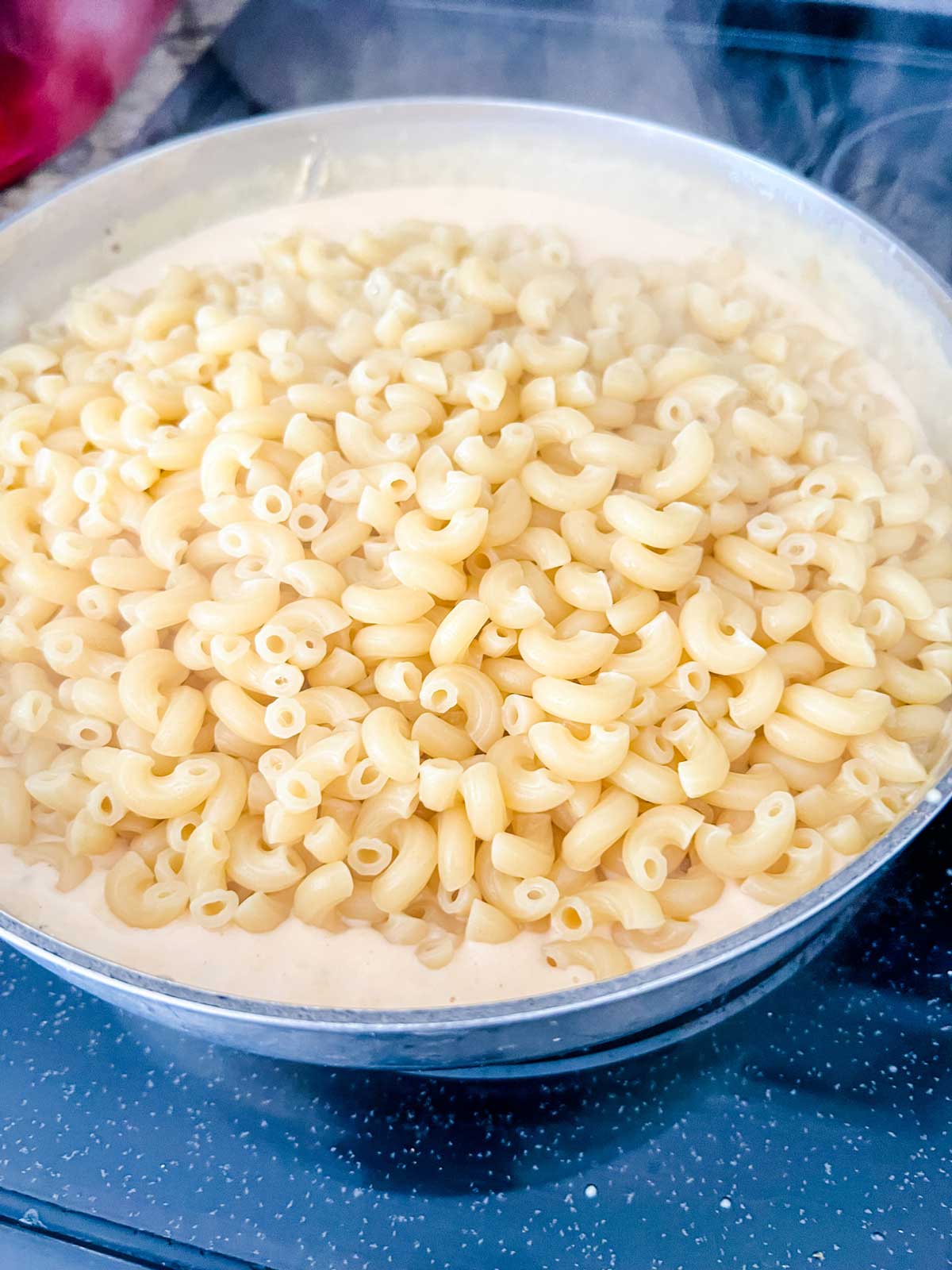 Pasta that has just been added to a cheese sauce.