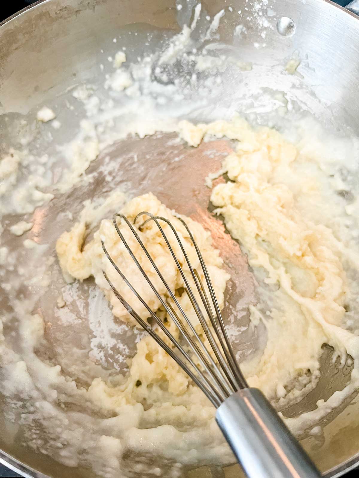 Photo of a roux cooking in a saucpan.
