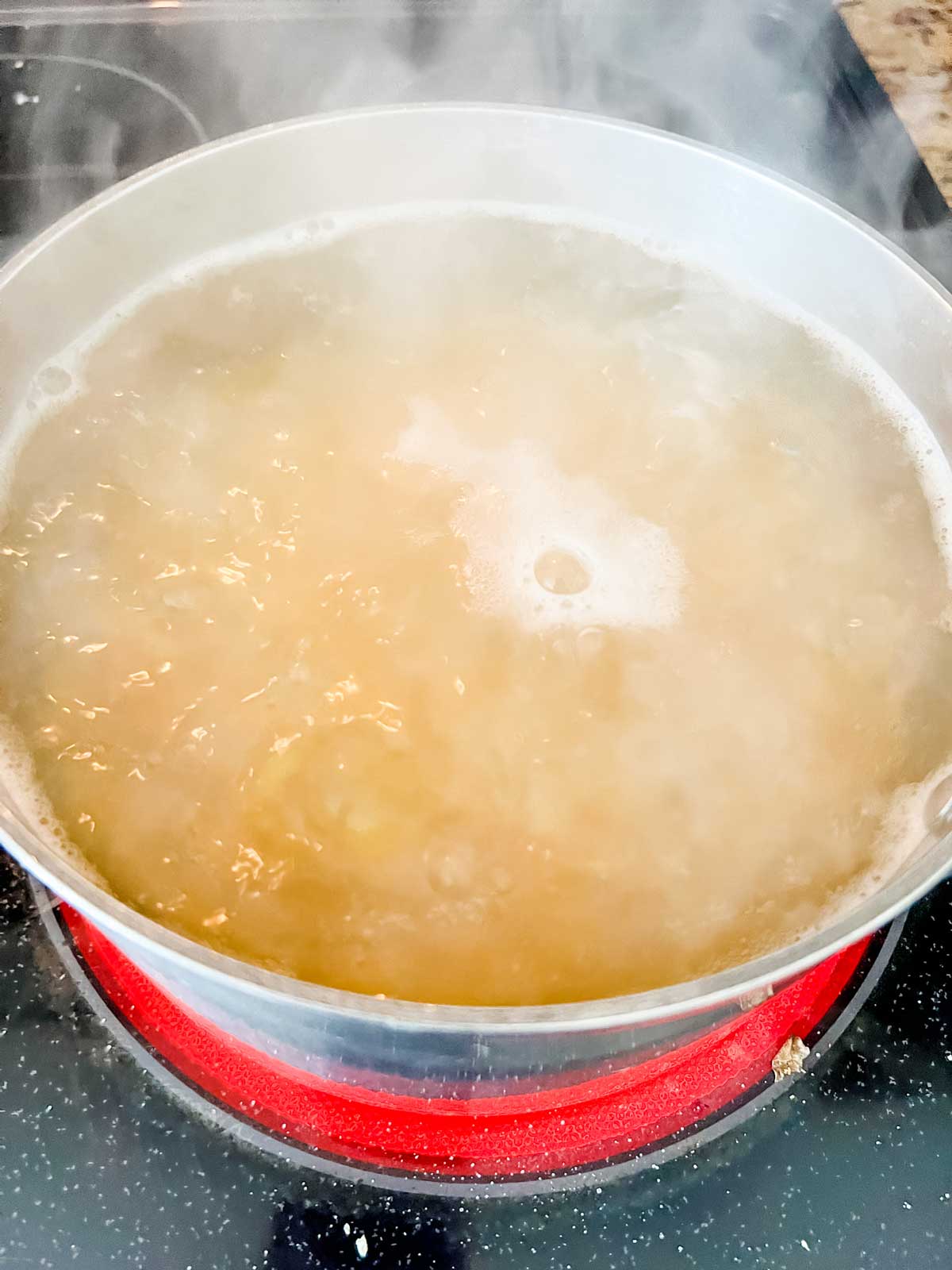 Pasta cooking in a pot on a stove.