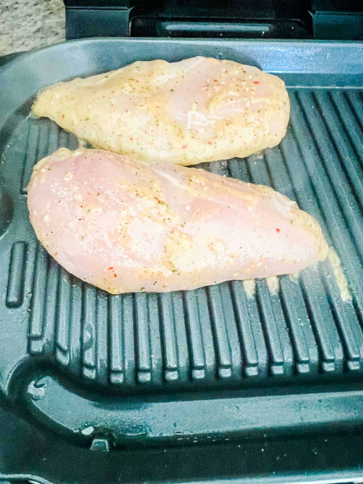 Chicken breast cooking on a Ninja Foodi grill.