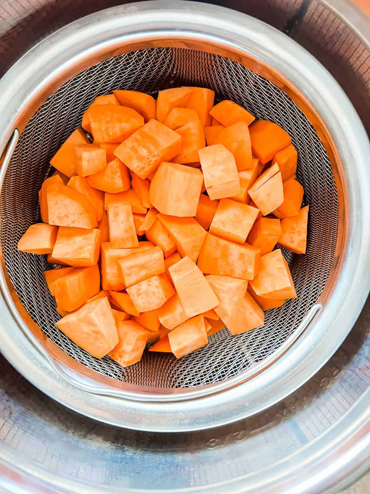 Sweet potatoes in a steamer basket set inside an Instant Pot.