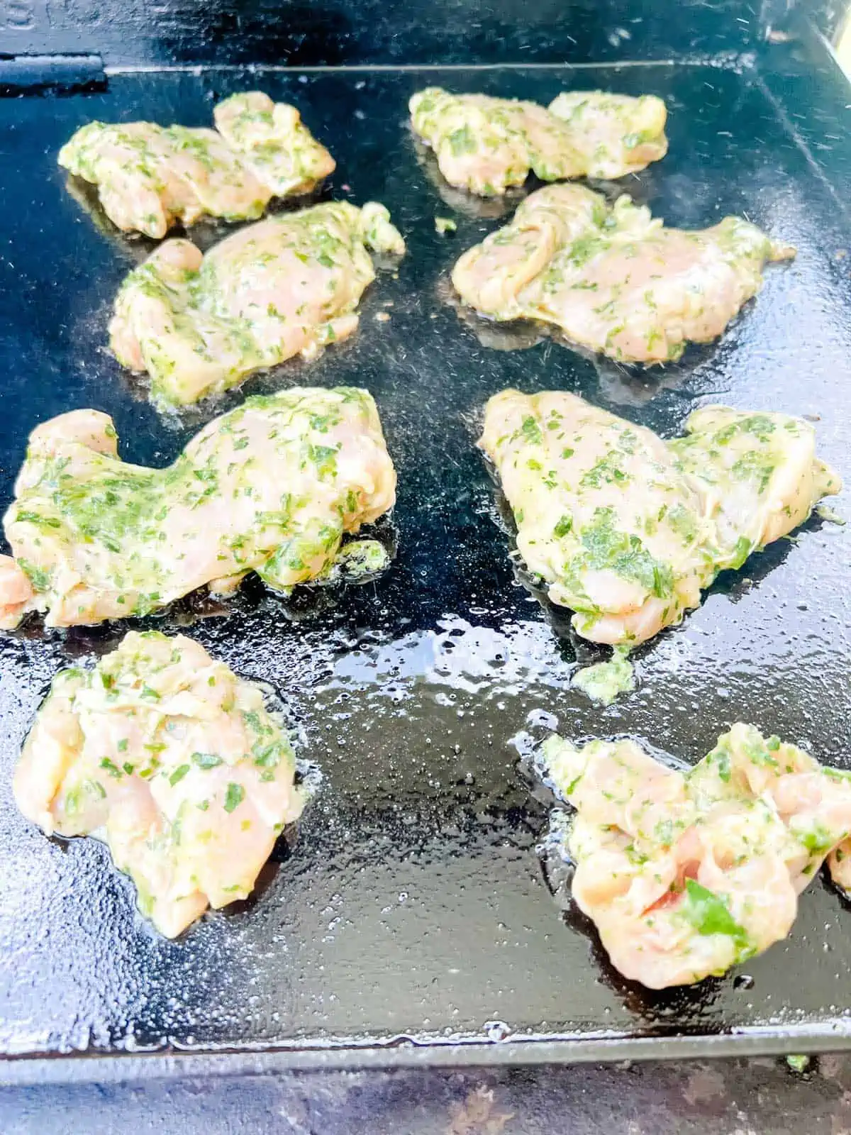 Photo of chicken thighs cooking on a Blackstone griddle.