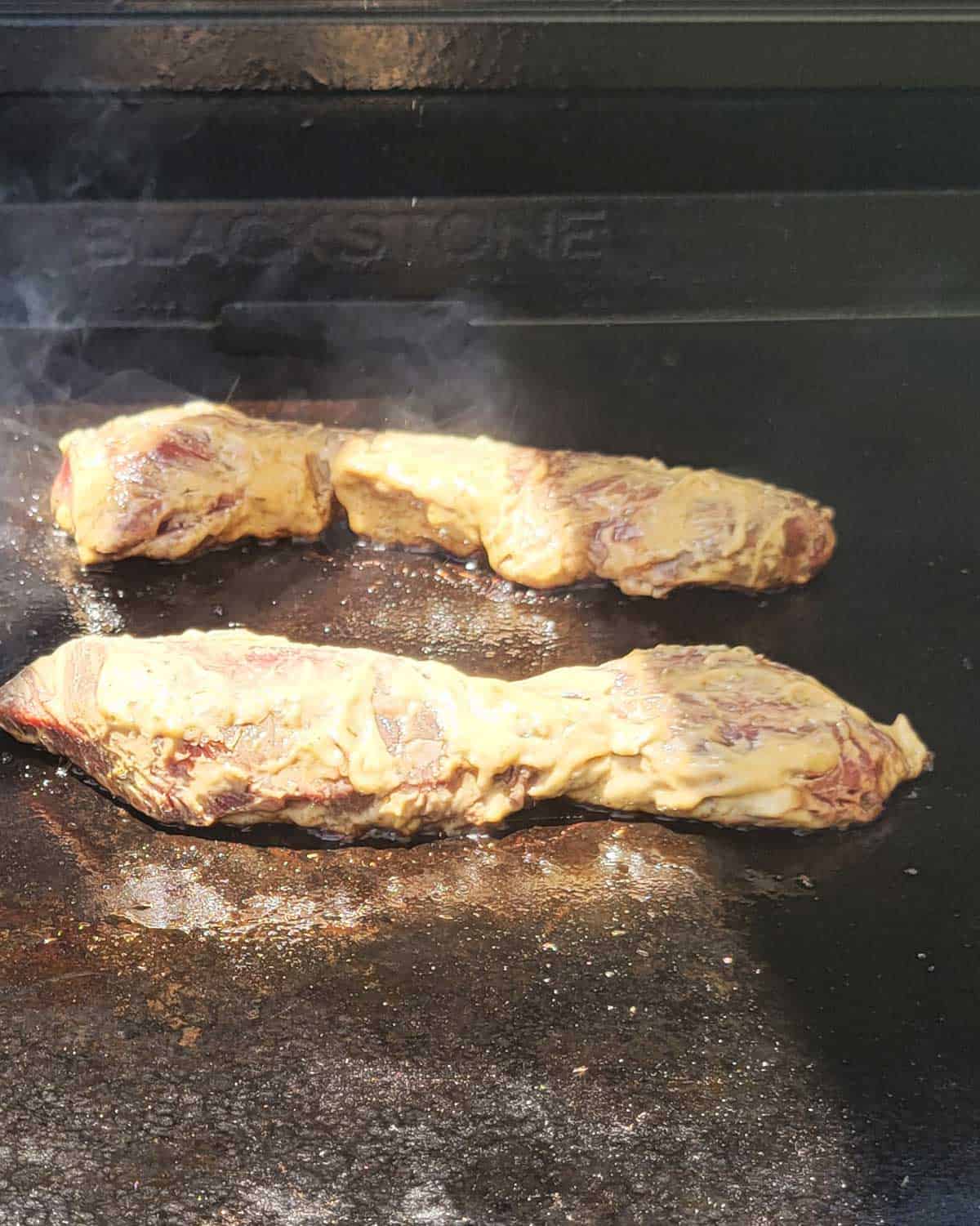 Photo of two hanger steaks cooking on a Blackstone Griddle.