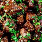 Close up square photo of a bowl of air fryer steak bites.