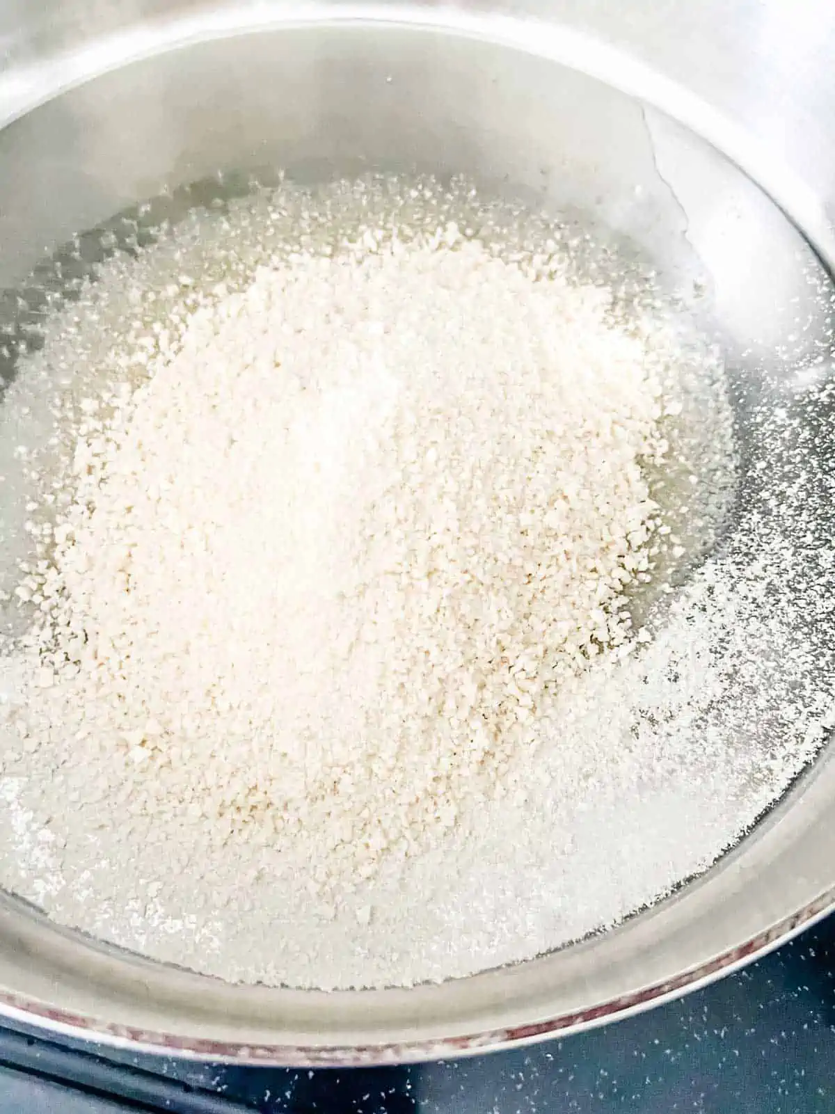 Photo of breadcrumbs toasting in a skillet of oil.