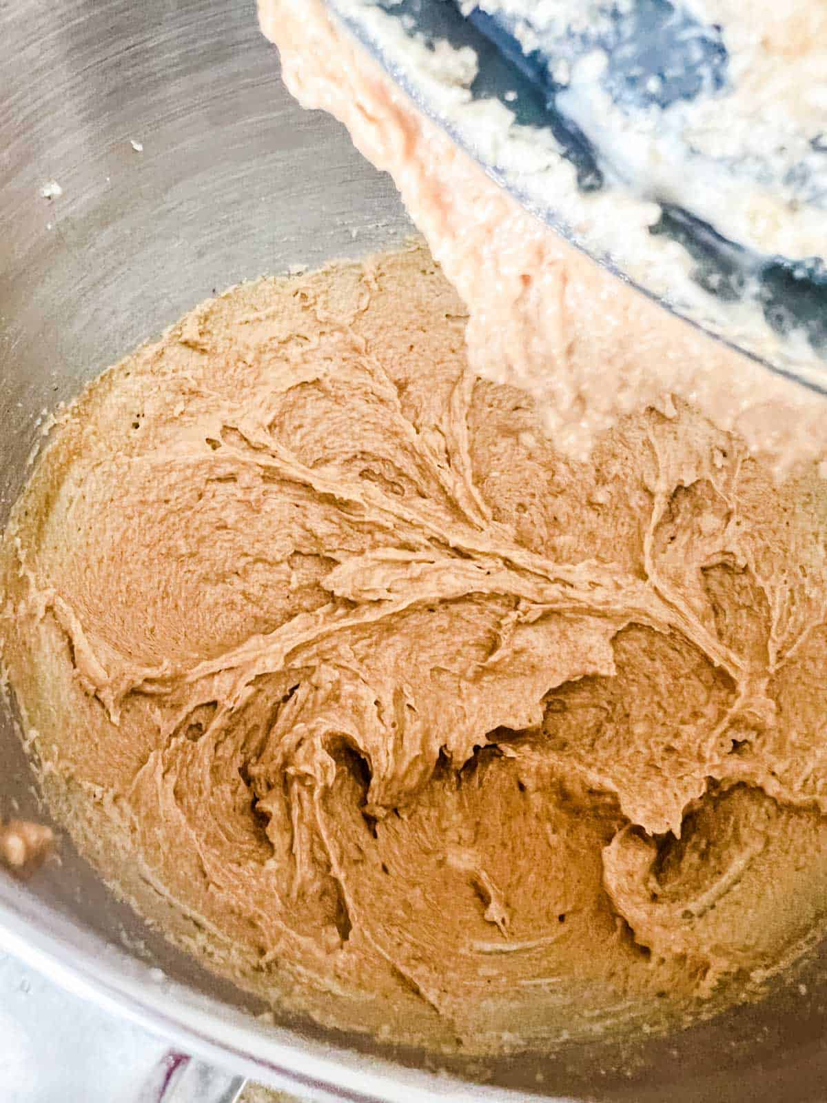 Peanut butter cookie dough being made in the bowl of a stand mixer.