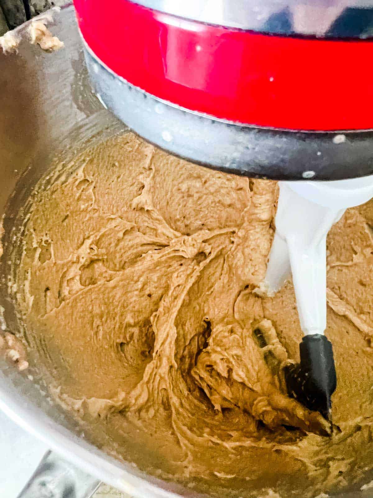 Peanut butter, butter, and sugars being mixed in a stand mixer.