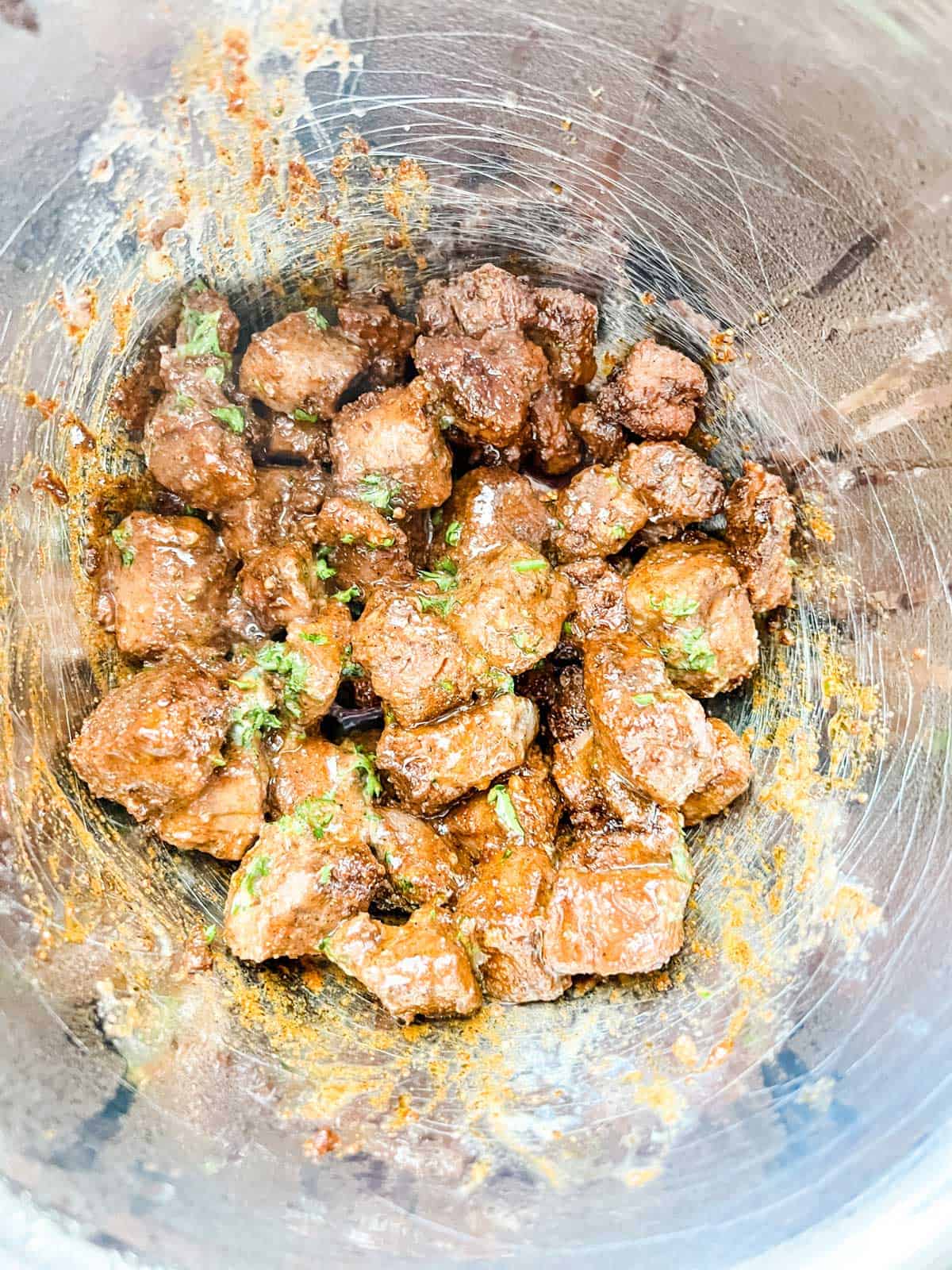 Photo of air fryer steak bites that have been tossed with garlic butter.