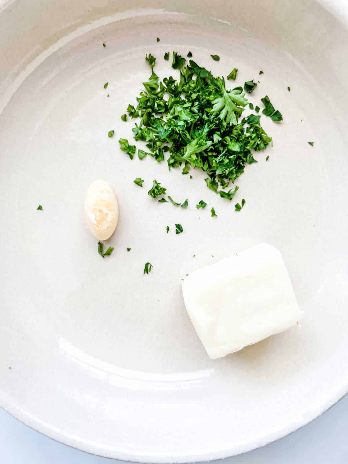 Photo of butter, garlic, and parsley in a bowl.