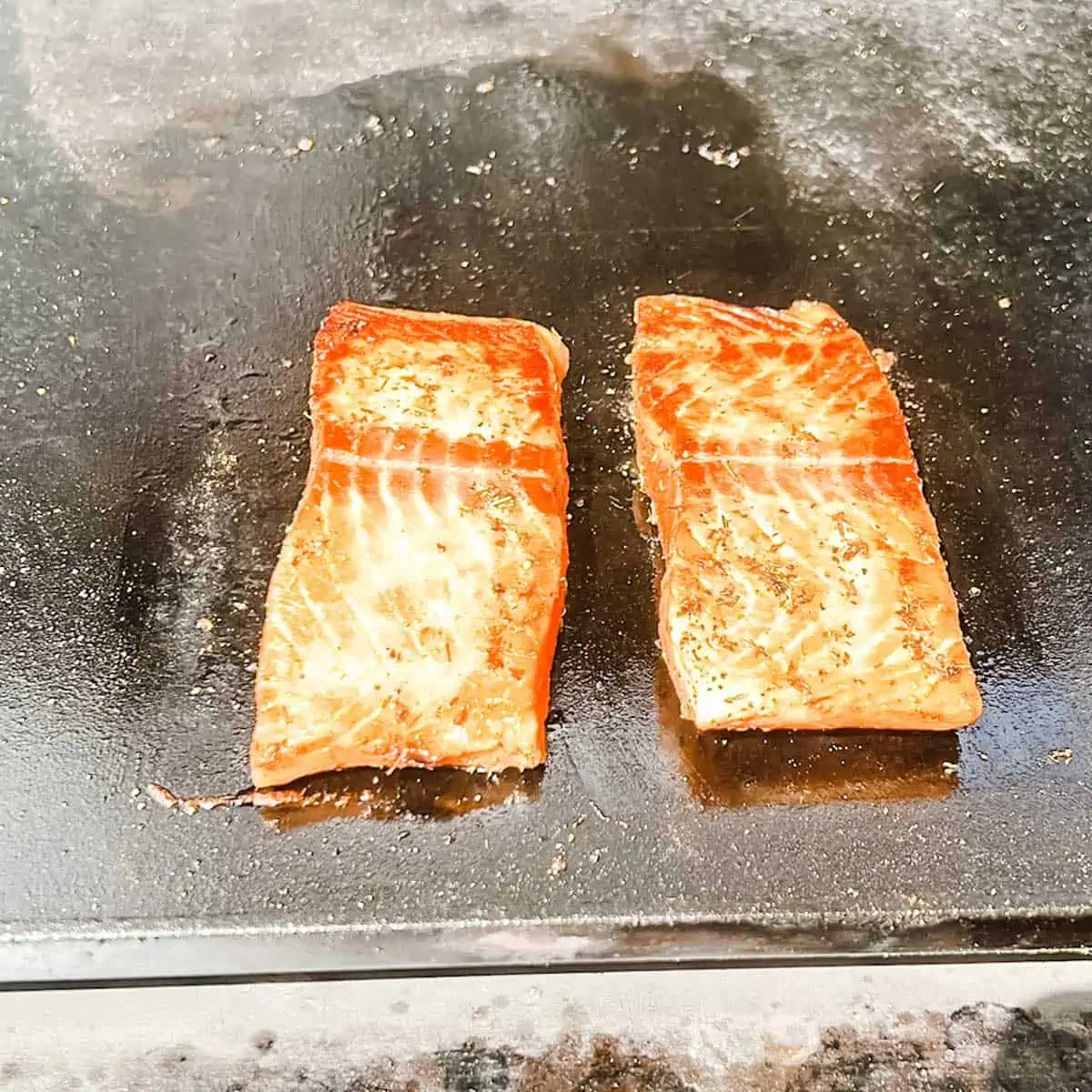 Photo of salmon cooking on a Blackstone griddle.