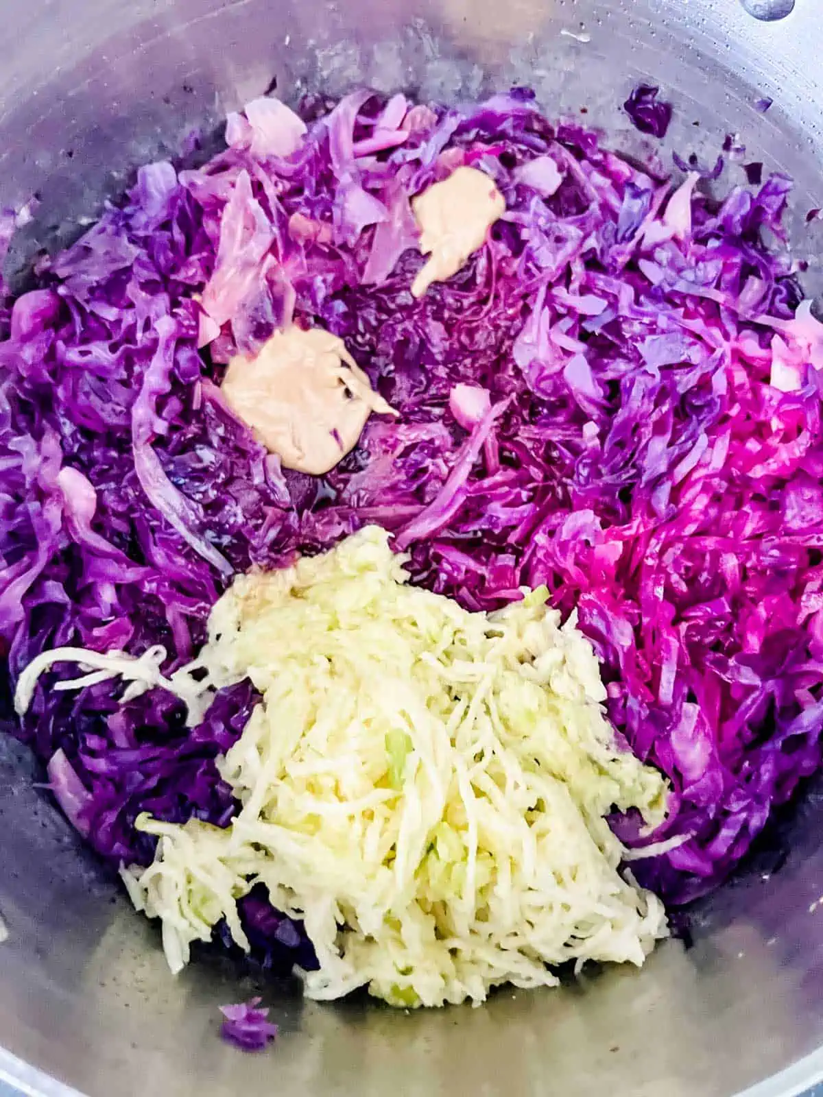 Photo of shredded apple being added to braised red cabbage.