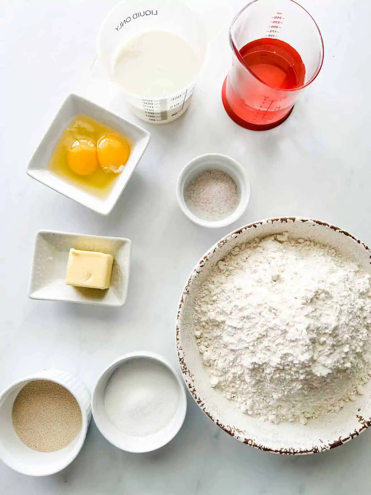 Photo of prep containers with milk, egg, salt, bread flour, sugar, and yeast to make bread machine buns.