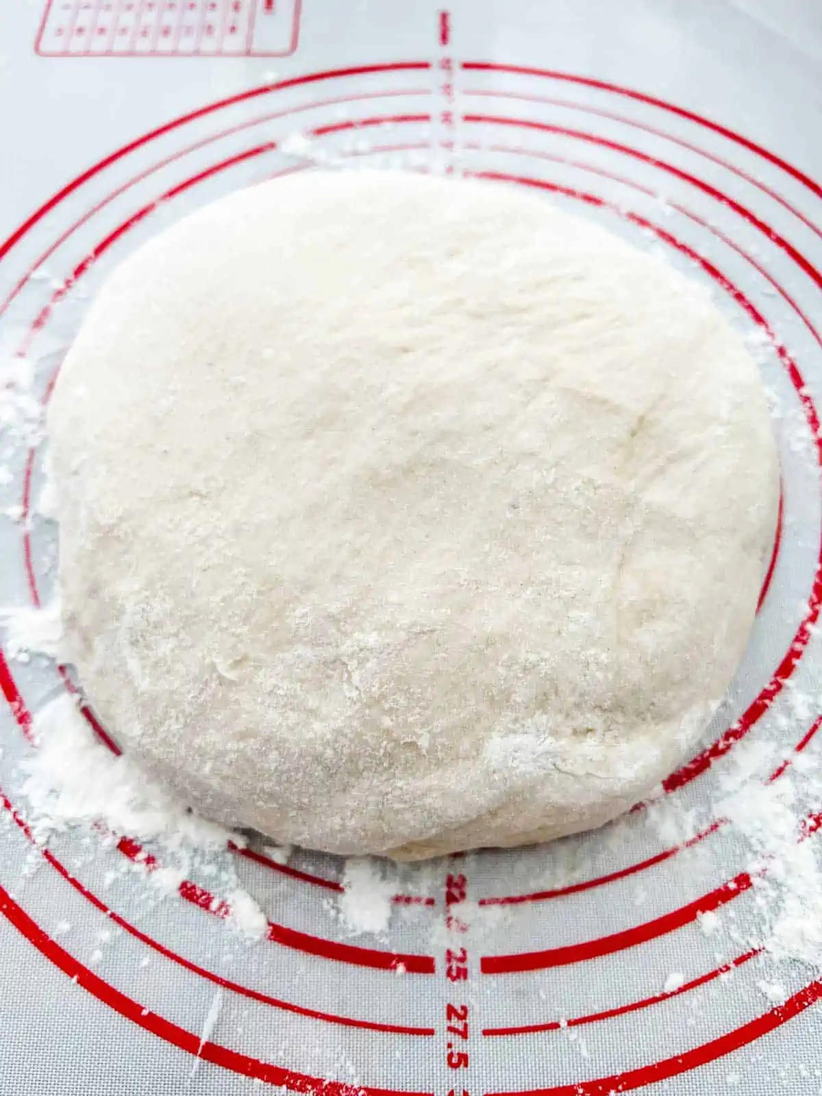 Photo of hamburger bun dough that has been turned out onto a floured surface.