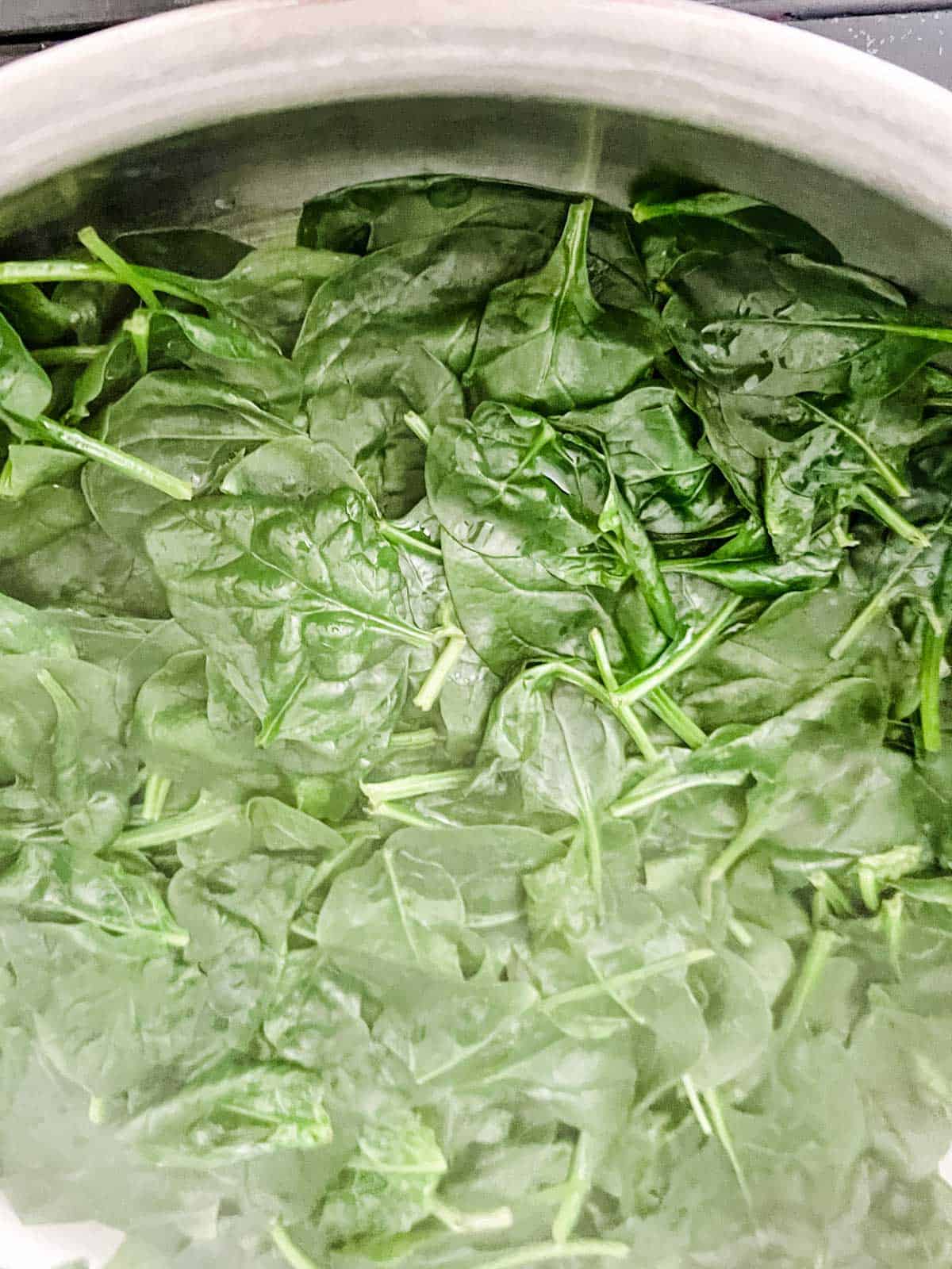 Baby spinach cooking in water.
