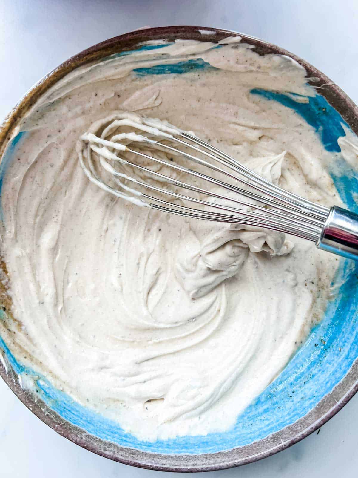 Photo of Greek Yogurt chicken salad dressing in a blue bowl.