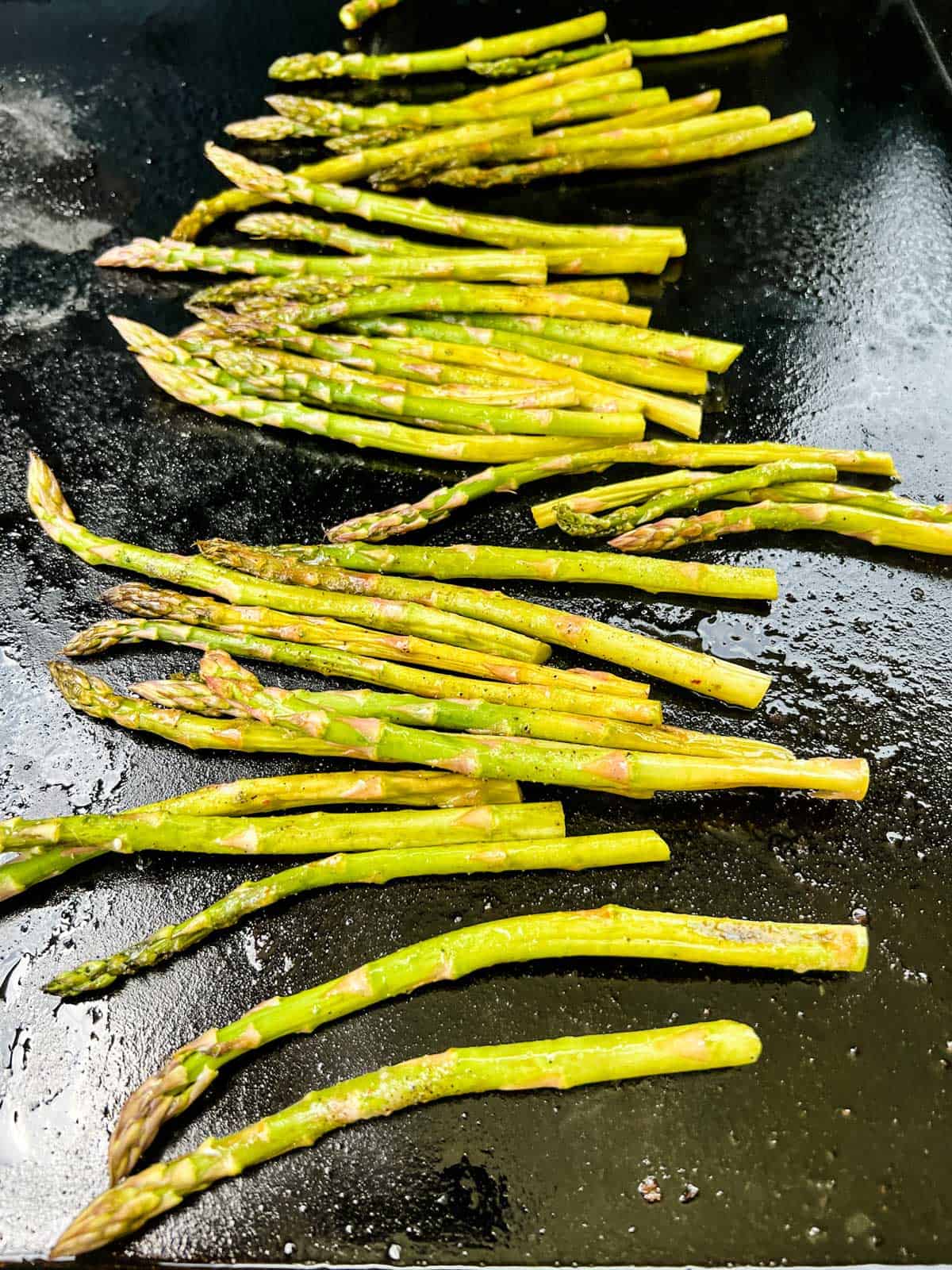 Photo of asparagus cooking on a Blackstone griddle.