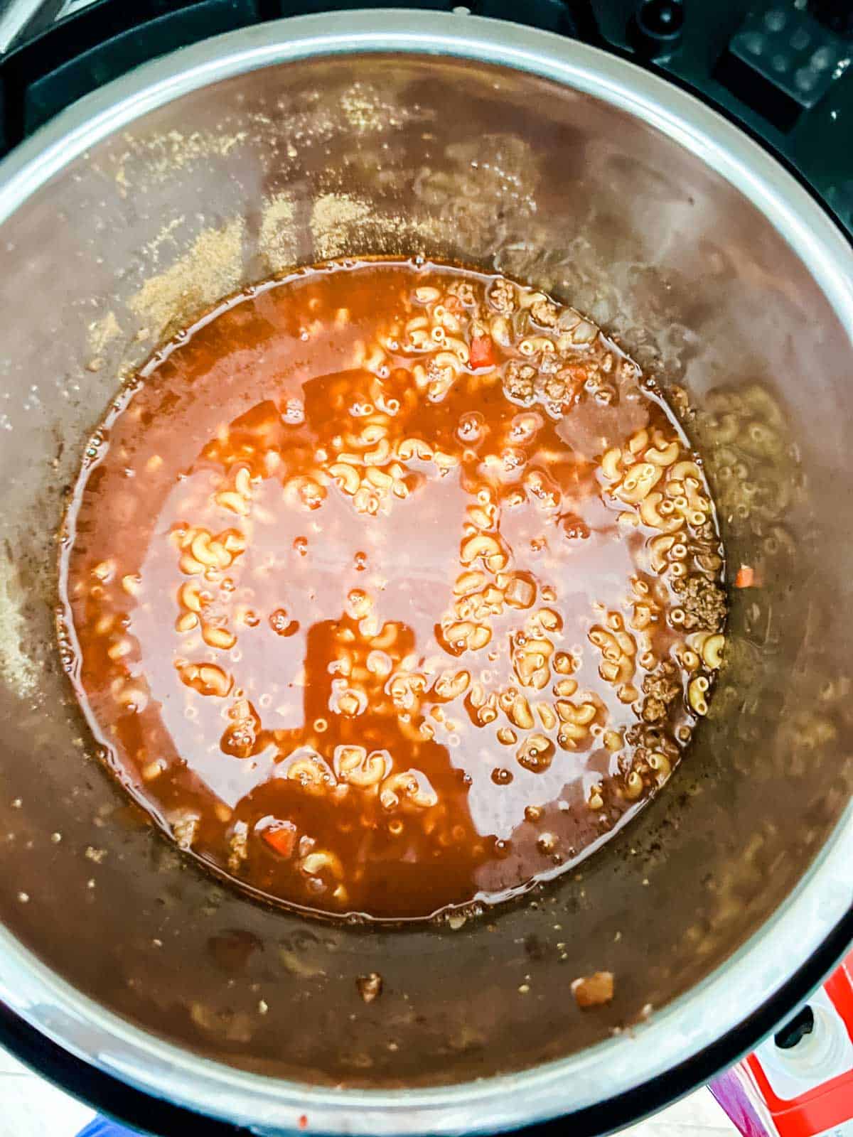 Noodles submerged in liquid in an Instant Pot.