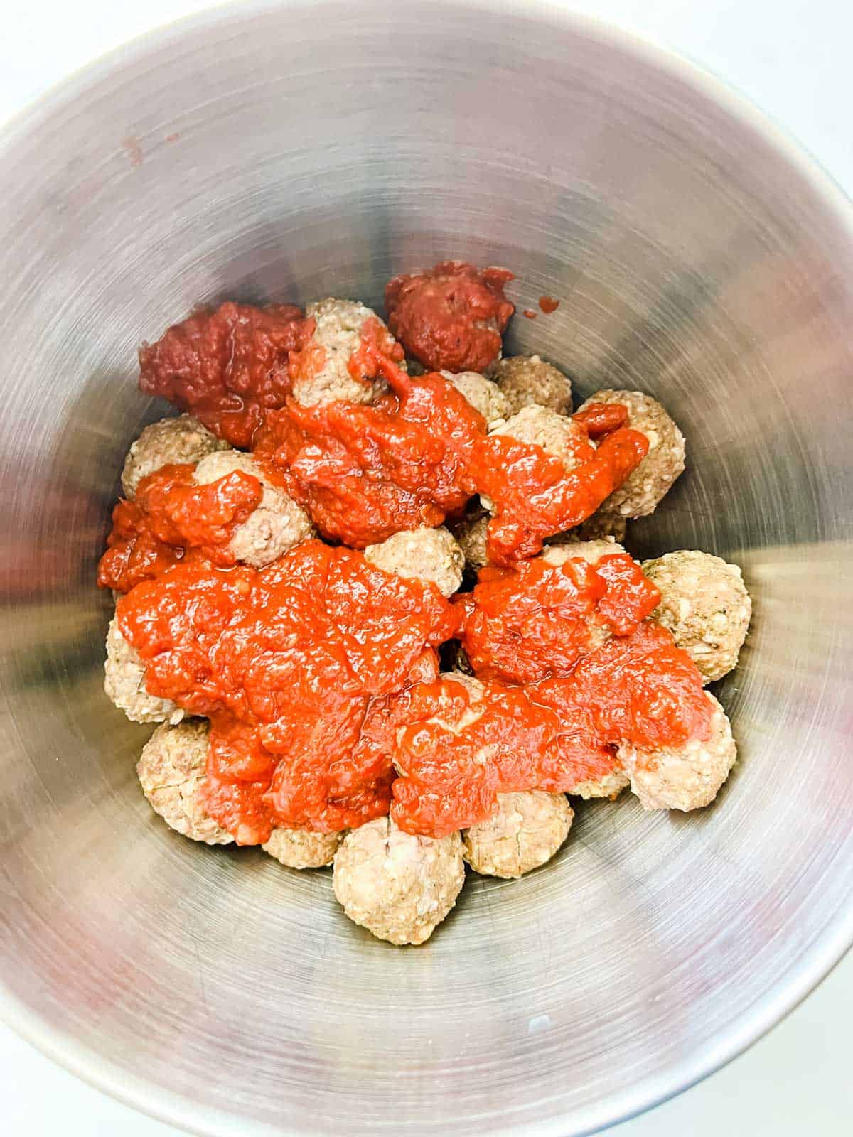 Photo of meatballs in a bowl with marinara.
