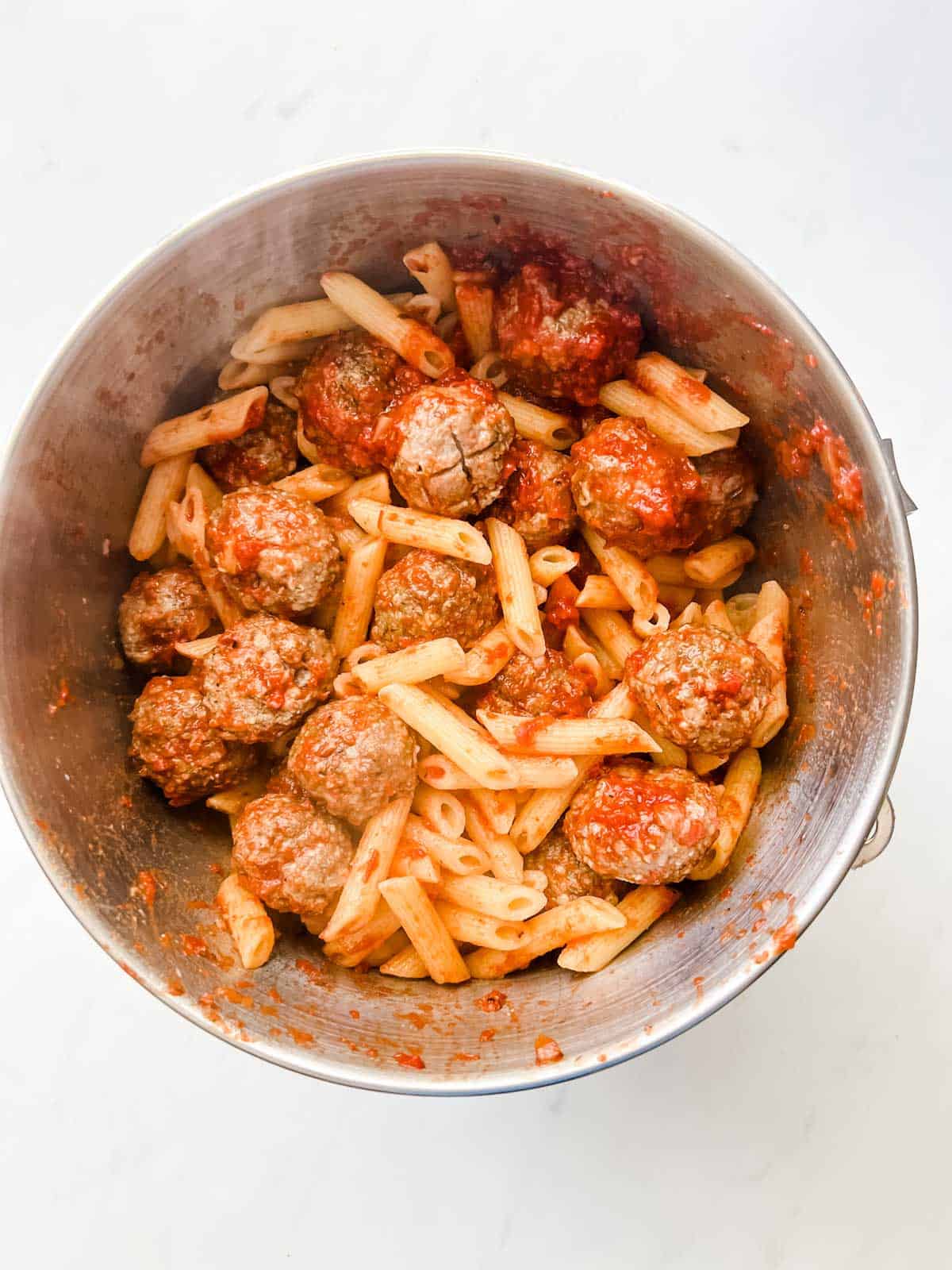 Photo of meatballs and penne in a casserole dish.