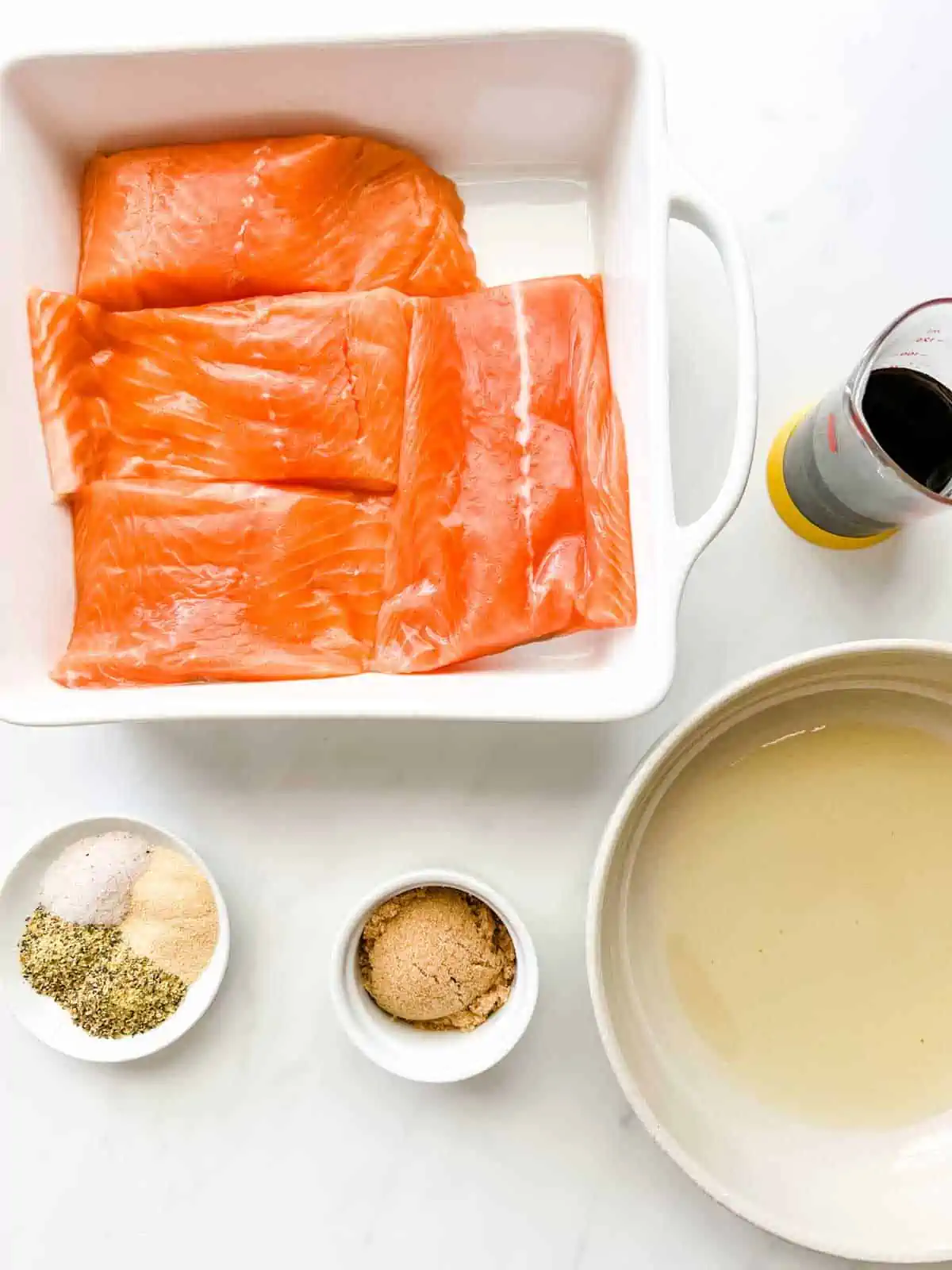 Overhead photo of salmon, oil, soy sauce, brown sugar, and seasonings.