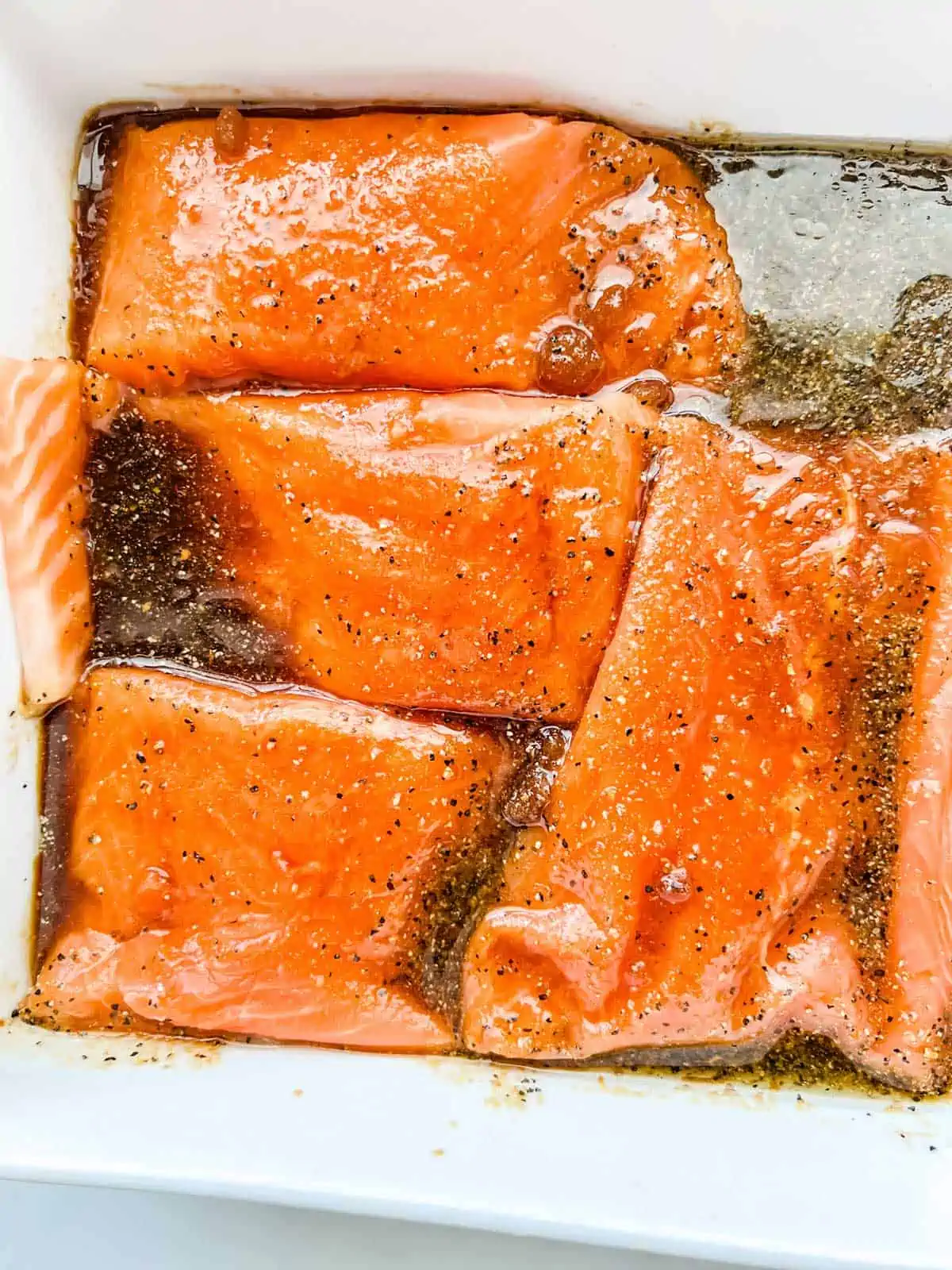 Photo of salmon marinating in a small dish.