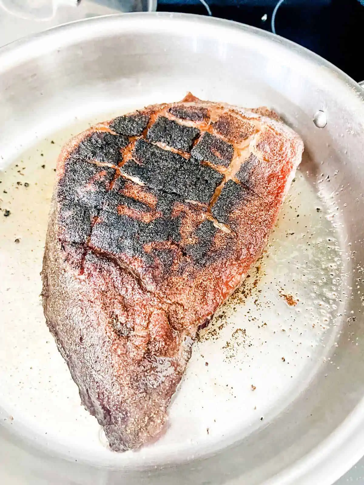 Photo of a picanha roast being seared.