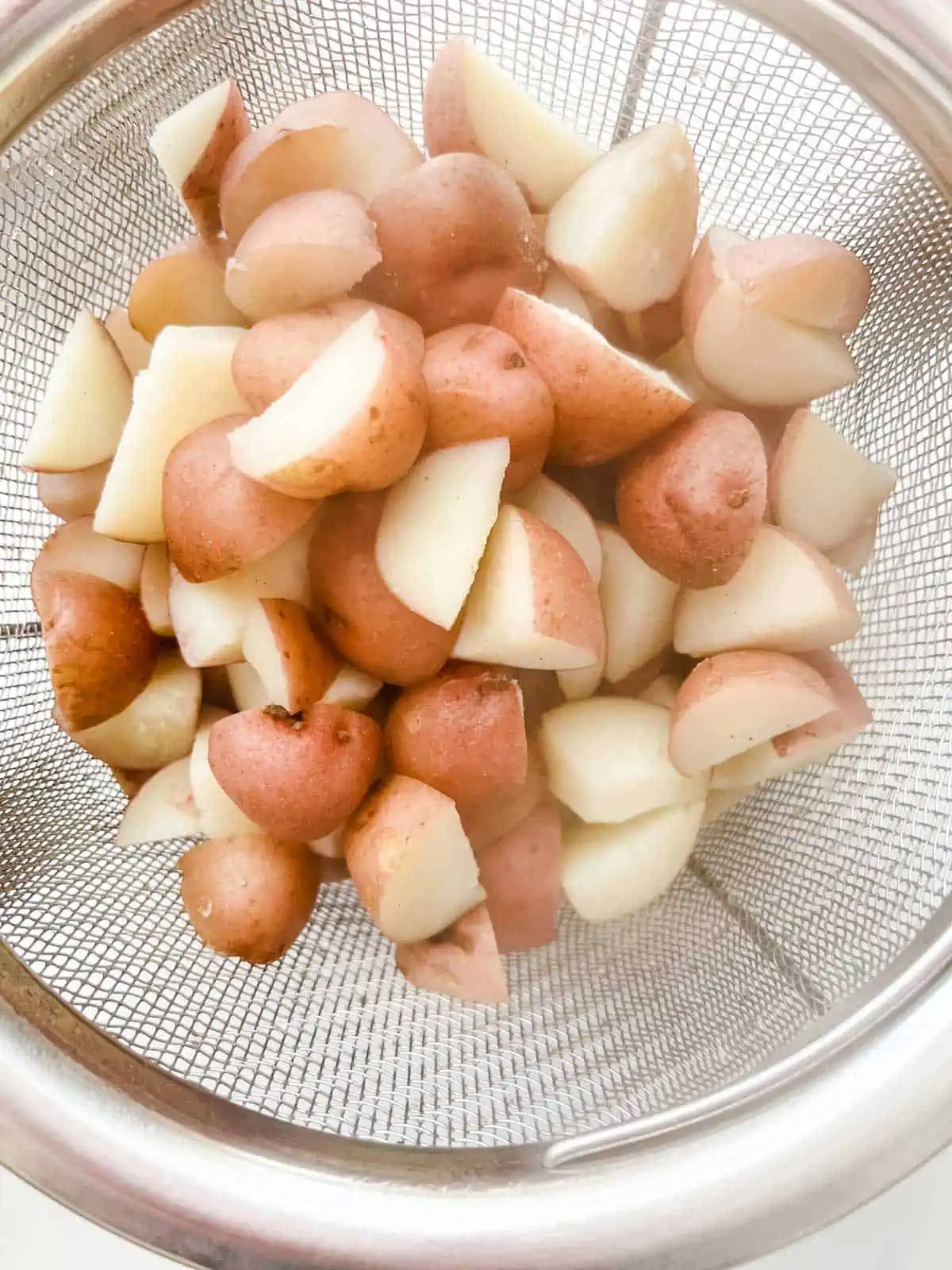 Photo of boiled potatoes in a strainer.