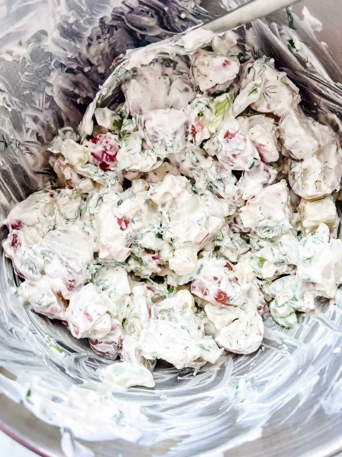 Photo of sour cream potato salad that has been mixed together in a bowl.