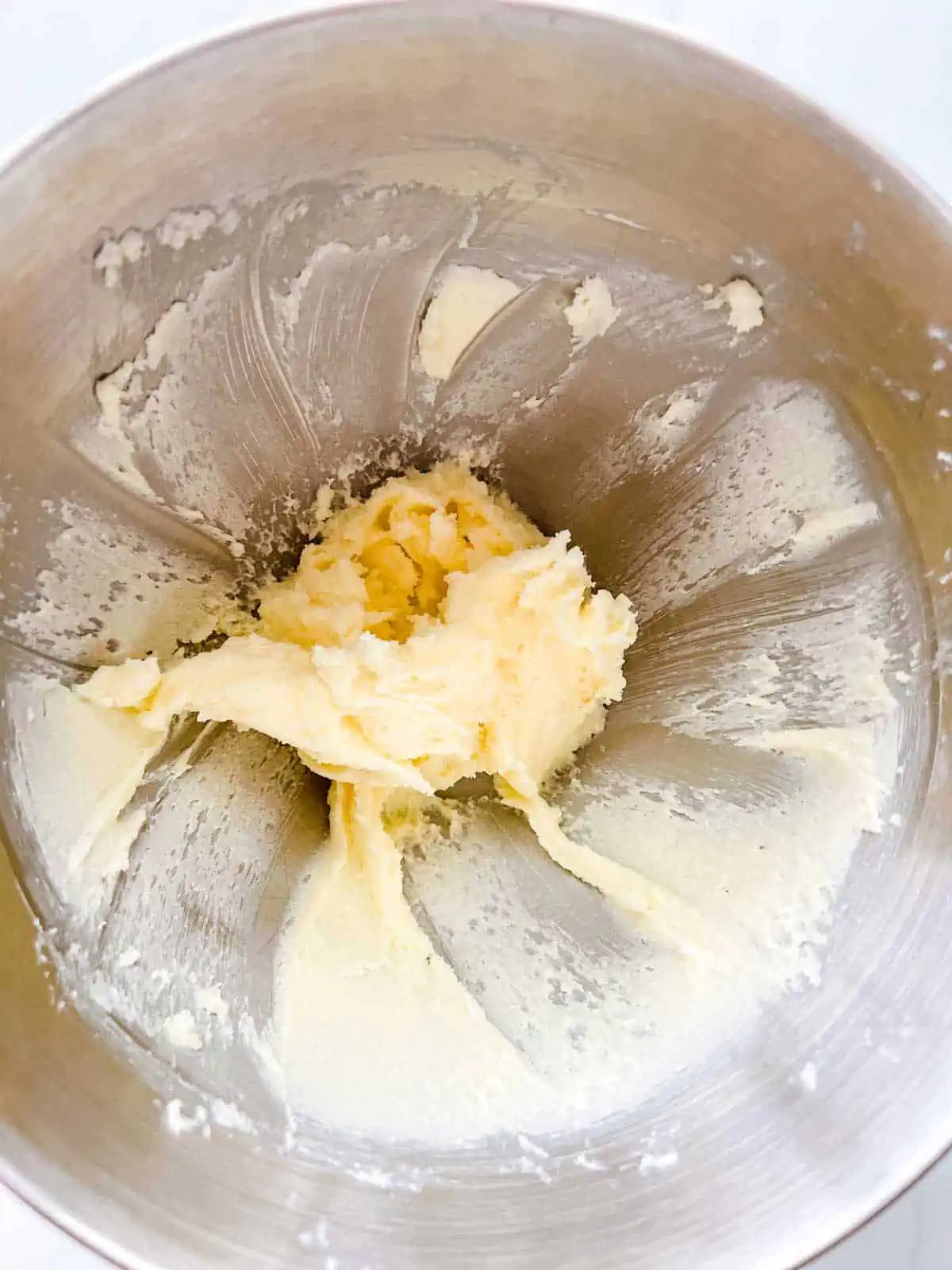Photo of butter and sugar that has been creamed in the bowl of a stand mixer.
