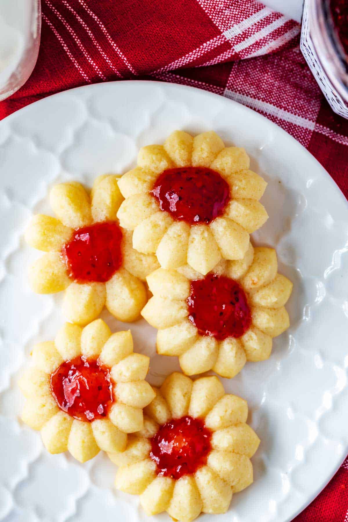Photo of thumbprint cookies with jam on a small white plate.