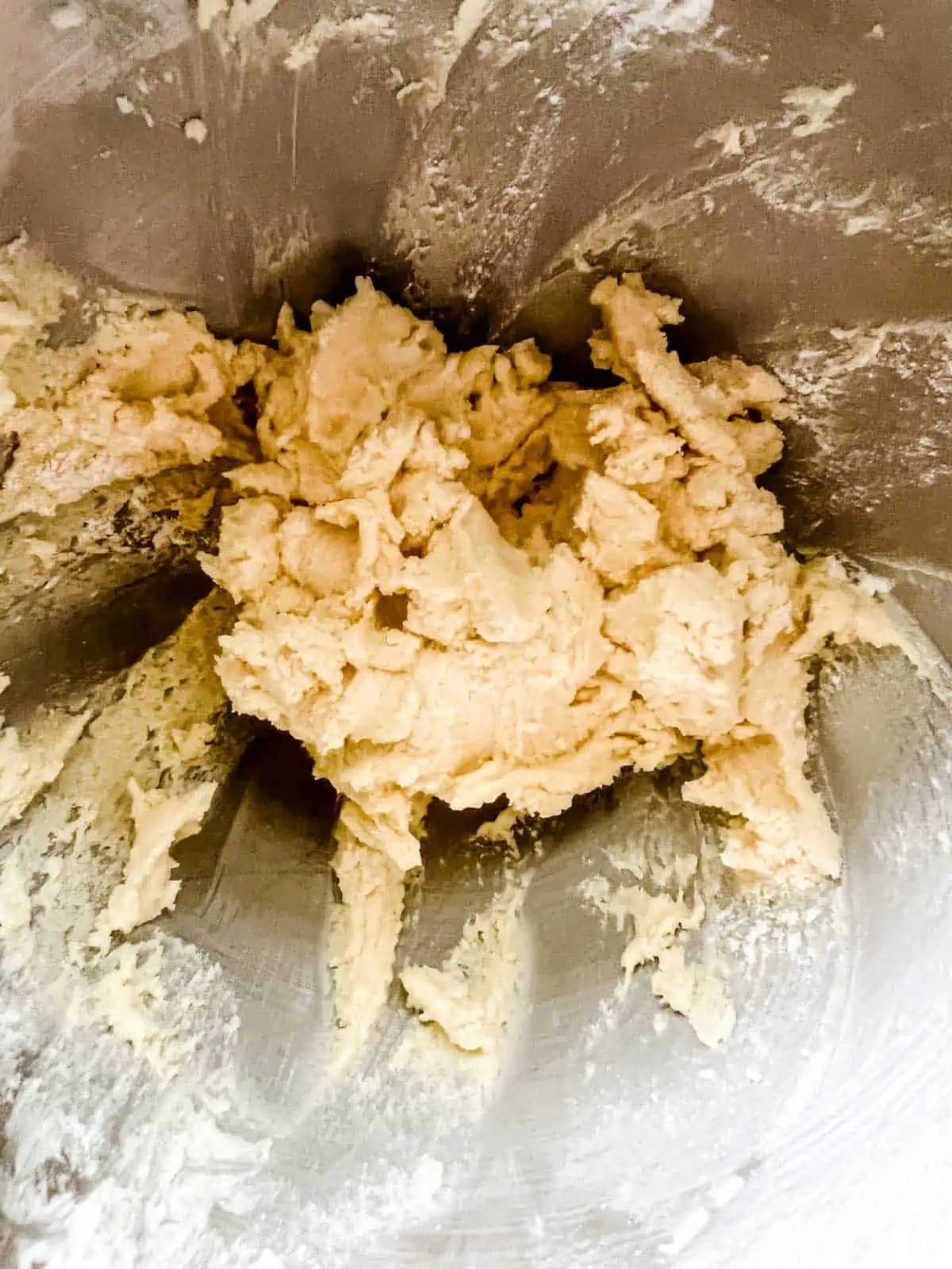 Photo of sugar cookie dough in the bowl of a stand mixer.