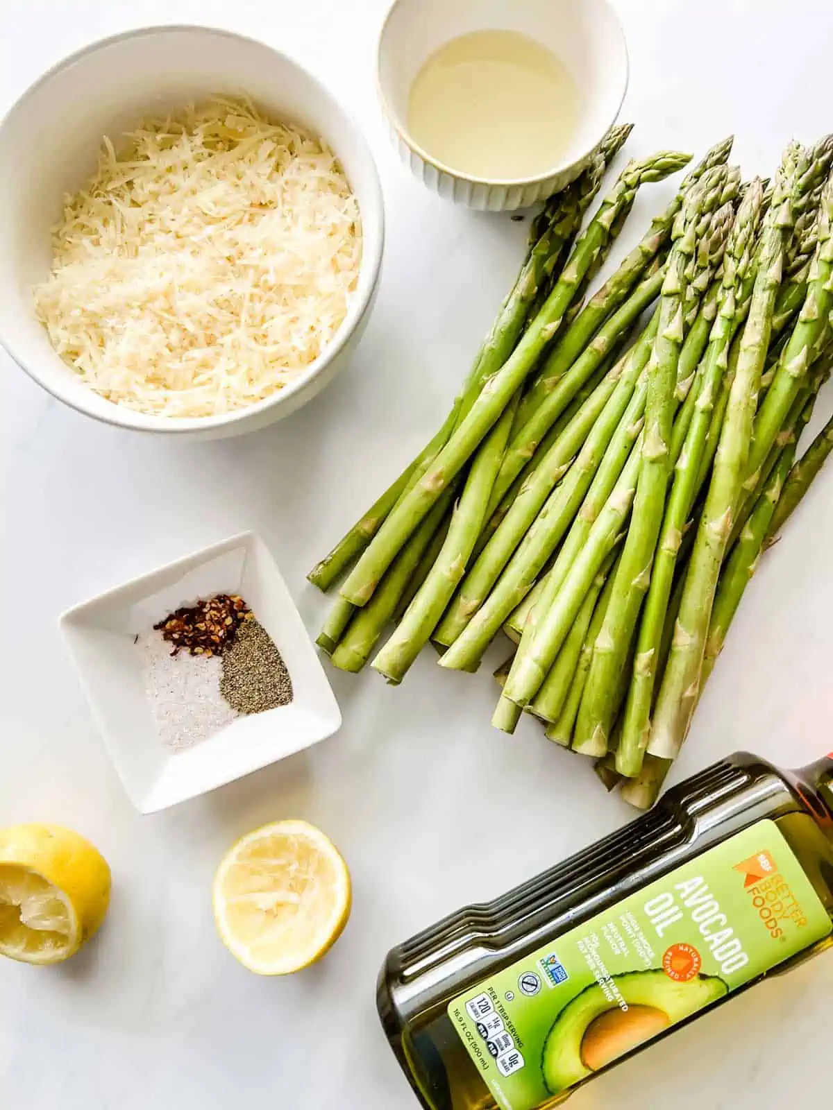 Overhead photo of asparagus, oil, lemon juice, seasonings and parmesan.